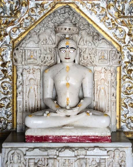 White marble idol within a carved shrine at the temple